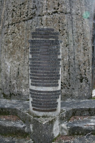 Dettaglio della Cappella di Partina, con il monumento commemorativo in primo piano e il suo sfondo roccioso.