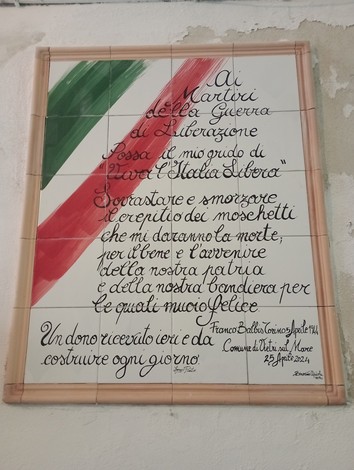 Lapidi in memoria dei martiri della guerra di Liberazione, con elementi decorativi tricolori.