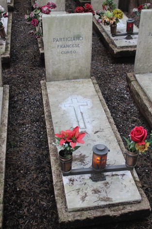 Tombe perpetue dedicate ai caduti per la Libertà, con decorazioni floreali e candele.