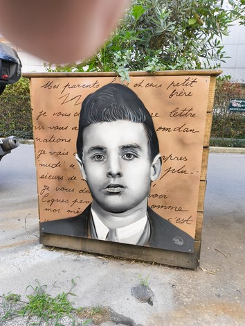 Targa commemorativa con ritratto di un membro del Gruppo Manouchian, simbolo di resistenza e lotta.