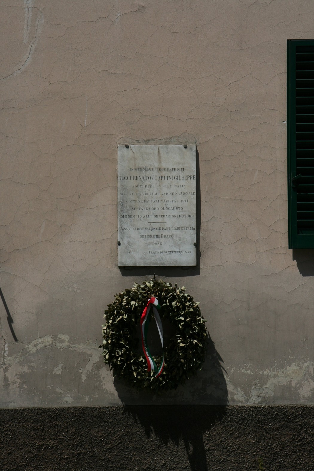Lapide commemorativa per Tucci e Carpini, adornata con una corona di alloro.