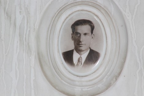 Sacrario dei partigiani di Torbella con un ritratto in bianco e nero di un uomo in giacca e cravatta.