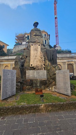 Monumento ai caduti, con statue e placche commemorative, circondato da elementi architettonici storici.