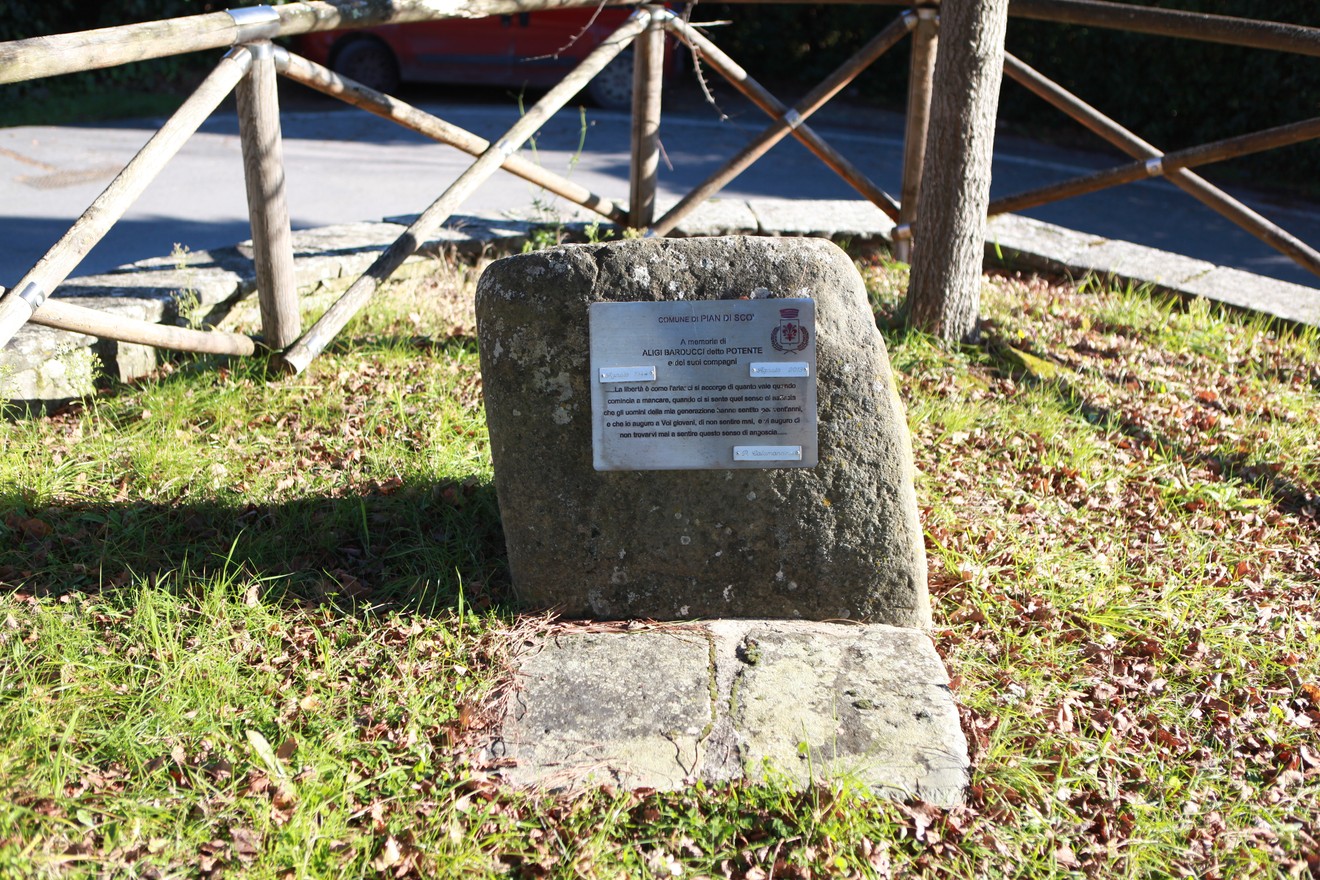 Cippo a Barducci, monumento storico collocato in un'area verde, circondato da una recinzione in legno.