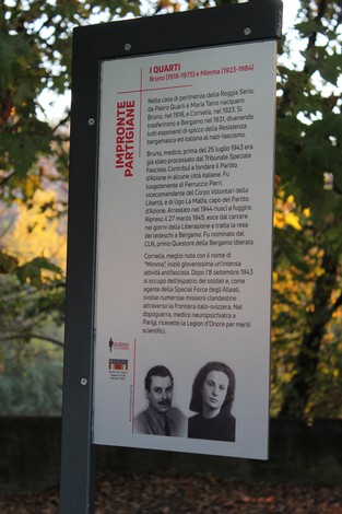 Targhetta commemorativa dedicata ai fratelli Quarti, partigiani italiani, con dettagli sulla loro vita e azioni.