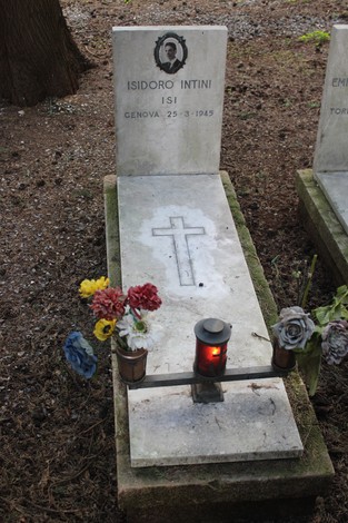 Tombe perpetue dedicate ai caduti per la Libertà, con fiori e una candela accesa.