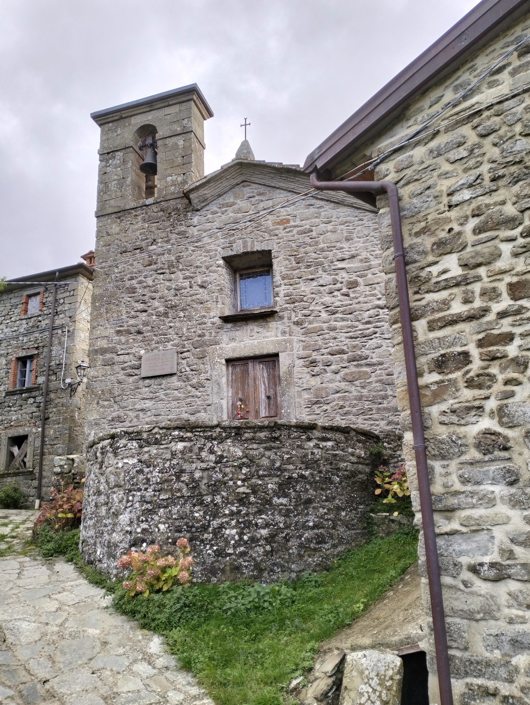 Lapide commemorativa a Nencetti, situata in un caratteristico borgo in pietra.