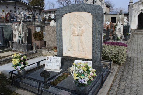 Monumento ai fratelli Pellegrini, ricco di dettagli e adornato con fiori, in un cimitero silenzioso.