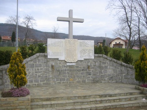 Monumento ai caduti di Tavigliano, memoriale in pietra commemorativo con croce e inscrizioni.