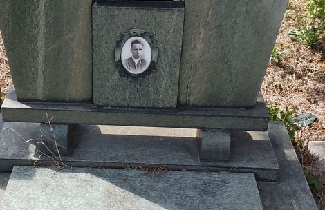 La tomba di Dossi presenta un monumento in pietra con una foto incastonata. Ambiente curato e silenzioso.