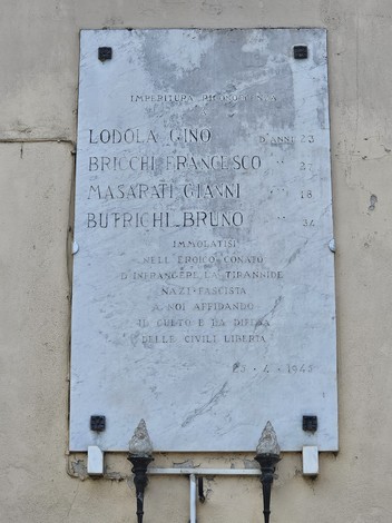 Lapide commemorativa in onore dei caduti per la libertà, incisa con nomi e date significative.