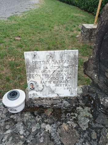 Monumento commemorativo dedicato a Pietro Cattaneo, situato in un'area verde, con dedica e foto.