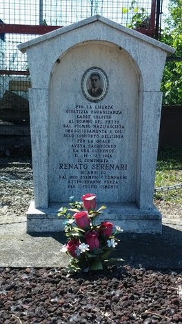 Cippo commemorativo dedicato a Renato Serenari, con fiori e iscrizioni in memoria del sacrificio per la libertà.