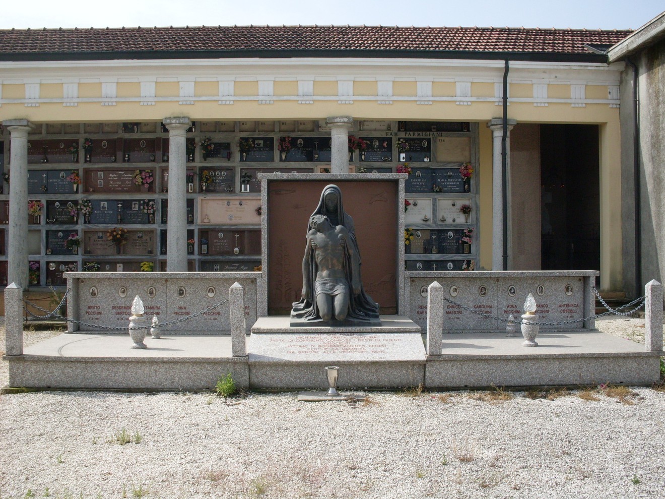 Sacrario delle vittime dei bombardamenti, commemorazione con statua e loculi in un'atmosfera di rispetto e memoria.