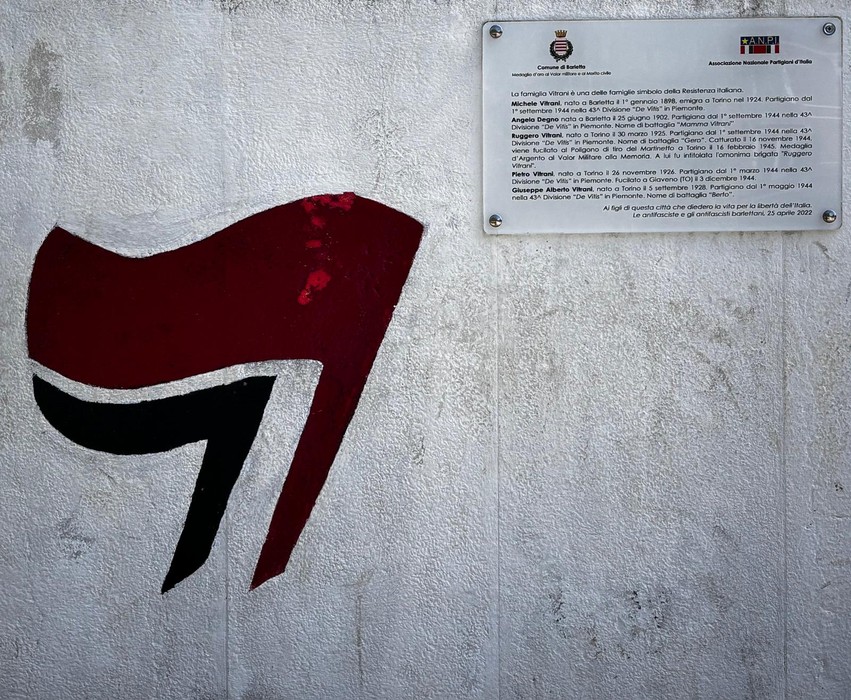 Murale dedicato ai fratelli Vitrani, con simboli in rosso e nero su sfondo chiaro.