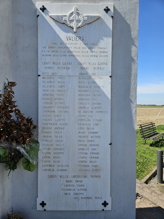 Monumento ai Caduti di Valliera, con iscrizioni commemorative e decorazioni floreali. Ambientazione rurale circostante.
