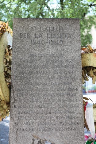 Monumento ai Caduti per la libertà, con iscrizioni commemorative e decorazioni floreali.
