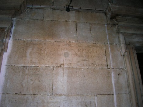 Iscrizione su una parete che celebra la memoria di un soggetto legato a Meloni.