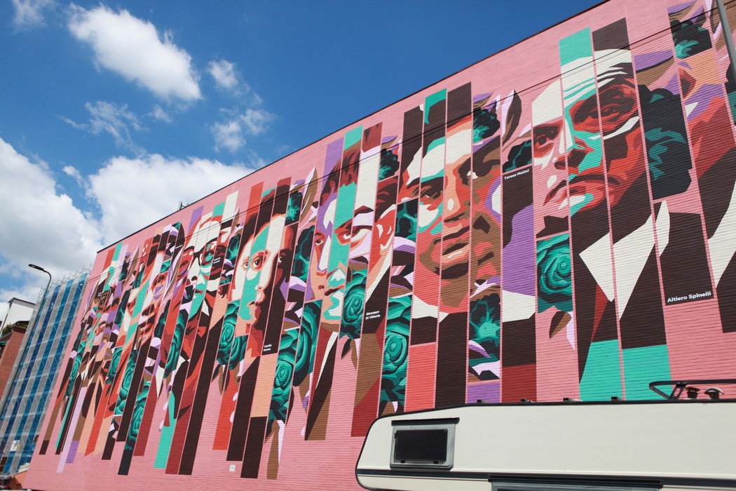 Murale che celebra la memoria degli antifascisti, con ritratti di figure emblematiche su sfondo colorato.