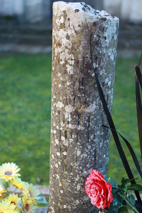 Cippo commemorativo dedicato ai caduti per la Libertà, immerso in un verdeio paesaggio.