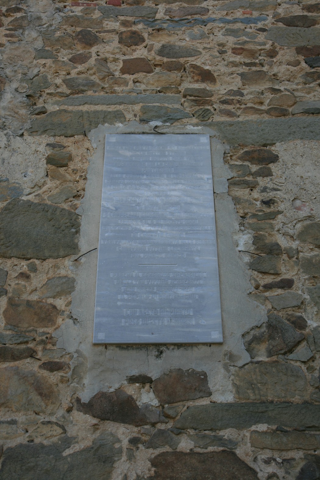 Lapide di Castel dei Gironi affissa su una parete di pietra, un elemento storico significativo.