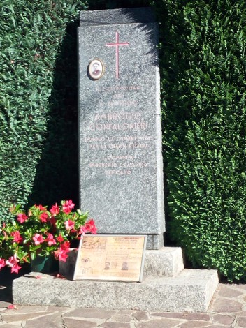 Monumento a Confalonieri, dedicato alla memoria e al contributo nella storia locale, circondato da vegetazione.