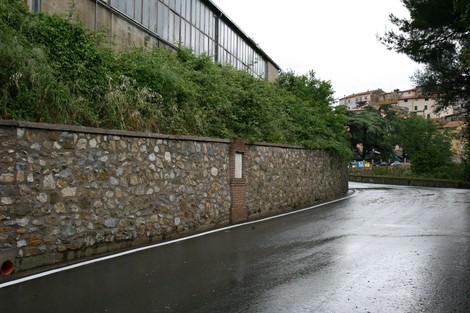 Lapide commemorativa dedicata a Ciardi, Landi, Gasperini e Pellegrini, affiancata da una strada asfaltata.