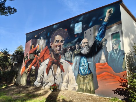 Murale colorato a Frosali, rappresentante figure storiche e simboli di lotta sociale.