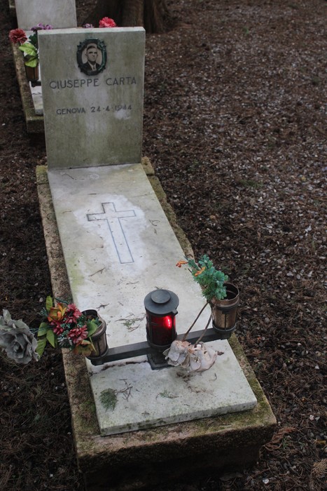 Tombe perpetue dedicate ai caduti per la Libertà, con decorazioni floreali e candele accese.