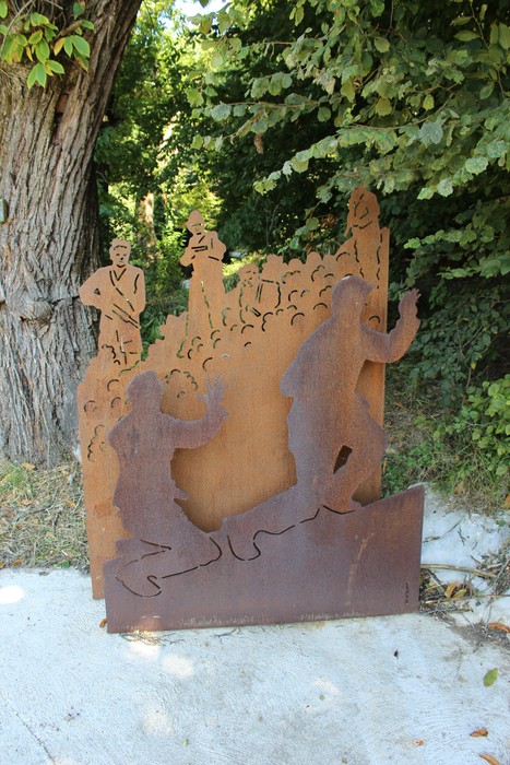 Scultura metallica che rappresenta figure umane in movimento, collocata lungo la Strada della battaglia di Fonteno.