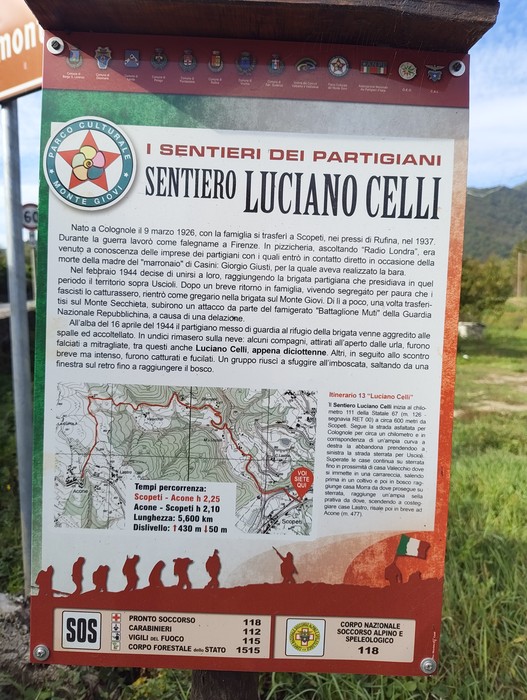 Pannello informativo con mappa e testo sul Sentiero Luciano Celli, fissato su supporto metallico all'aperto.