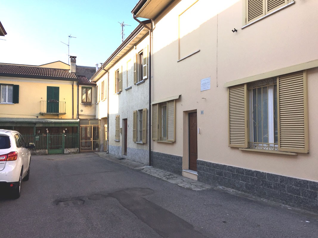 Lapide dedicata a Montanari in una strada tranquilla, circondata da edifici residenziali.