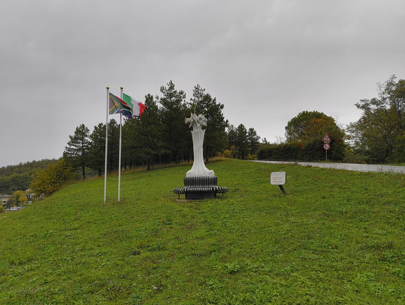 Monumento ai soldati sudafricani, simbolo di memoria e riconoscenza, circondato da bandiere e natura.
