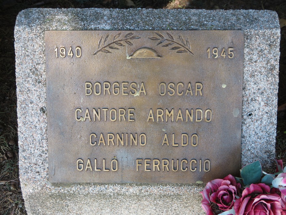 Cippi del viale della rimembranza, commemorazione di caduti con lastre in bronzo e decorazioni floreali.