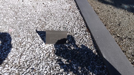 Monumento ai partigiani caduti di Brugherio, circondato da ciottoli bianchi e un'area ben curata.