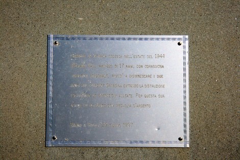 Cippo commemorativo dedicato a un giovane partigiano, simbolo di coraggio e resistenza.