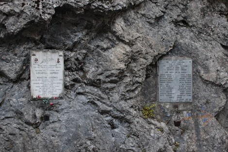 Lapide commemorativa ai caduti della 86a Brigata Garibaldi, collocata su una parete rocciosa.