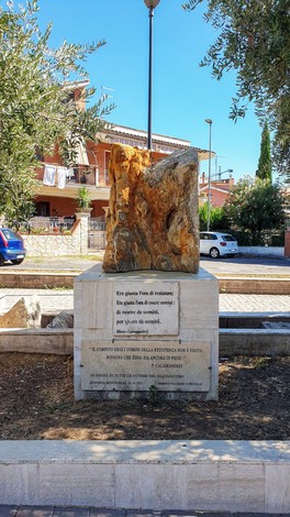 Monumento al 25 Aprile, dedicato alla libertà e alla resistenza, con un elemento di roccia su base in pietra.