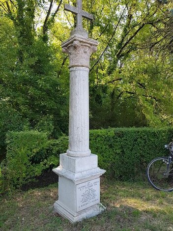 Monumento commemorativo dedicato all'eccidio del Caffè del Doro, situato in un contesto naturale.