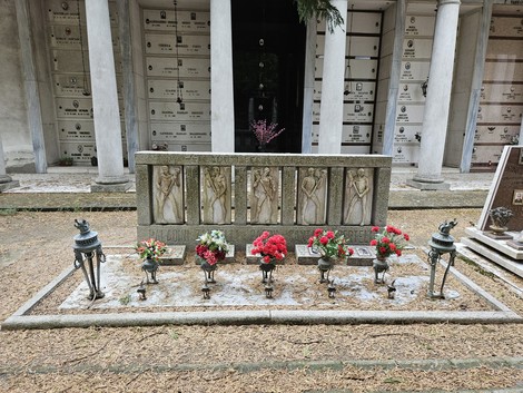 Sacrario ai Caduti per la Libertà con monumento in pietra e fiori freschi, situato in un cimitero.