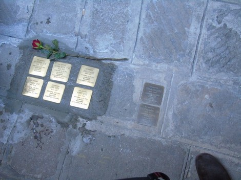 Pietre d'inciampo dedicate alla famiglia Levi - Grassini, collocate in un pavimento con una rosa sopra.