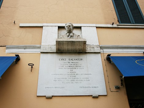 Lapide commemorativa dedicata a Livio Salvatori, situata su una facciata di edificio.