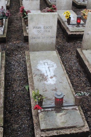 Tombe perpetue dedicate ai caduti per la Libertà, adornate con fiori e candele in un cimitero sobrio.