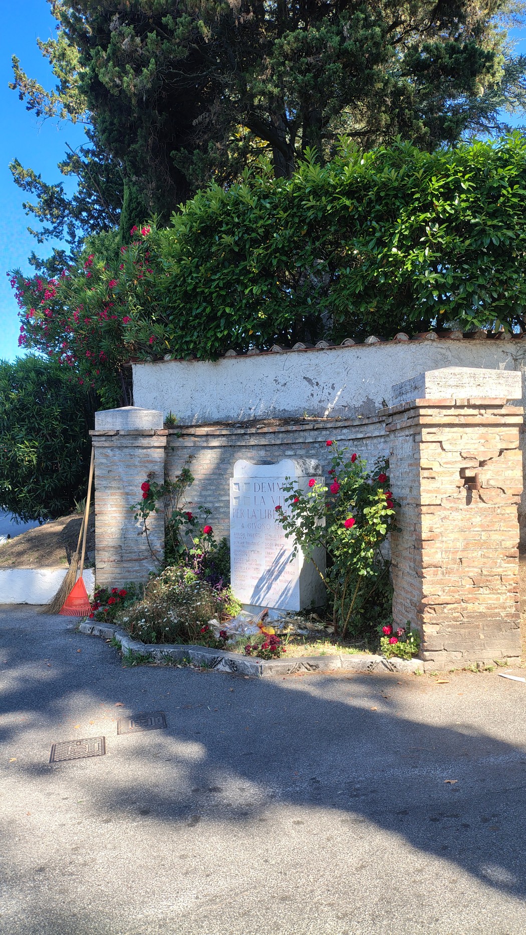 Lapide commemorativa in un'area verde, contornata da piante e fiori, dedicata ai martiri de La Storta.