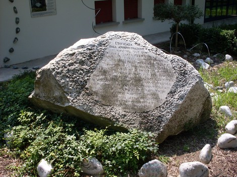 Monumento commemorativo dedicato alle scuole Varini, situato in un'area verde.