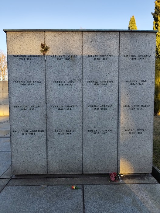 Monumento commemorativo con nomi di personalità, immerso in un contesto sobrio e suggestivo.