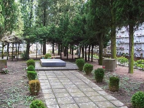 Spazio commemorativo "Il Quadrato del Non Mollare" immerso nella vegetazione, a simboleggiare la memoria e la resilienza.