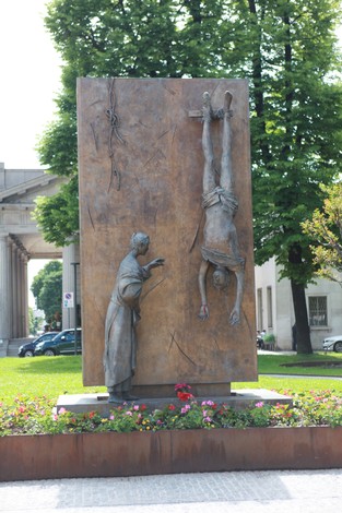Monumento al partigiano con una statua che rappresenta un soldato in una posizione drammatica.