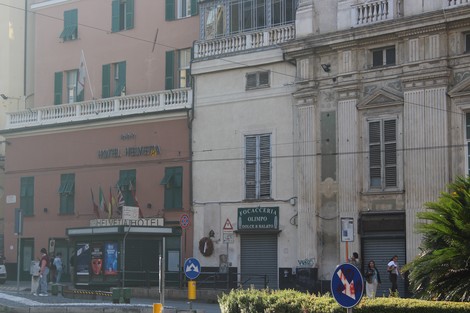 Immagine di una lapide commemorativa dedicata ai caduti per la Libertà, circondata da edifici storici.