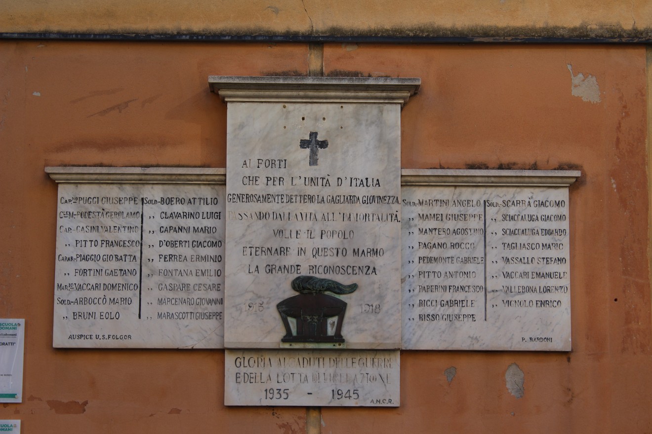 Lapide commemorativa dedicata ai caduti per la libertà, con nomi e date incisi su marmo.